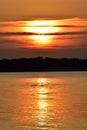 Golden lake sunset Partially hidden sun cloudy