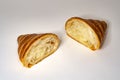 Flaky laminated croissant bun cut in half on white background, artisanal French viennoiserie Royalty Free Stock Photo