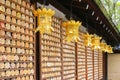 Golden lanterns hanging in front of mirror-shaped wooden preyer