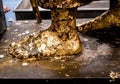 Golden leaf taped and Thai bath coin on Buddha foot statue