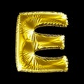 Golden letter E made of inflatable balloon isolated on black background.