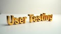Golden letters spelling user testing on a neutral surface in a studio setting