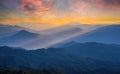 Golden light rays shining down to mountains. Sun rays over valley. Sun rays over hill. Beam of light from clouds on the mountains Royalty Free Stock Photo