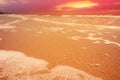 Golden light reflecting off a water wave at the sea and sand on sunset. Pure Gold Tone Royalty Free Stock Photo