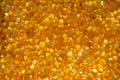 Close up of orange silica gel dessicant. Golden translucent beads with shiny light