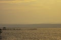 Golden light of sunrise behind the mountains in the sea and the shadow of the wooden bridge at Trat in Thailand