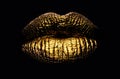 Golden lips closeup. Gold metal art lip. Beautiful makeup. Golden lip gloss on beauty female mouth, closeup. Sensual