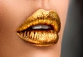 Golden lipstick closeup. Metal gold lips. Beautiful makeup. Sexy lips, bright paint on beautiful model girl`s mouth, close-up Royalty Free Stock Photo