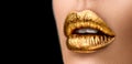 Golden lipstick closeup. Metal gold lips. Beautiful makeup. Sexy lips, bright paint on beautiful model girl`s mouth, close-up Royalty Free Stock Photo