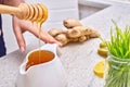 Golden liquid Organic Honey on a drip pouring Green wheat, lemon and ginger for a detox smoothie Royalty Free Stock Photo