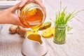 Golden liquid Organic Honey pouring from jar. Green wheat, lemon and ginger for a detox smoothie Royalty Free Stock Photo