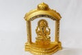 Golden lord Ganesha Hindu idol designed in a stage in a white backdrop. Macro with extremely shallow depth of field