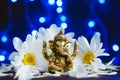 Golden lord ganesha sculpture in daisy flowers over blue illuminated background. Celebrate lord ganesha festival Royalty Free Stock Photo