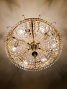 Golden luxury chandelier or luster with crystal pendants and circle rows of diamond shaped glass gems