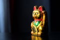 Golden Maneki Neko, the Lucky Cat, covered with dust. The concept of time and expectation of good luck