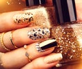 Golden manicure with gems and sparkles. Bottle of nailpolish, trendy accessories Royalty Free Stock Photo