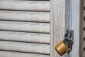 Golden metal closed padlock on old wooden blinds