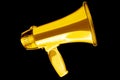 Golden megaphone black background isolated closeup, gold metal loudspeaker, loudhailer, speaking trumpet, bullhorn, announcement Royalty Free Stock Photo