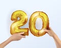 Golden metal balloon number twenty 20. party decoration with Golden balloons. The number 20 is in your hand.Anniversary sign for a