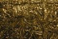 Golden metal foil, wrinkled and shiny. Close-up, abstract image background