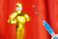 Hollywood Golden Oscar Academy award statue and hand in gloves with vaccine aganist coronavirus on blue background.