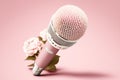 Golden metal microphone decorated with pink flowers, pink bright background, copy space. Grunge, nostalgia Royalty Free Stock Photo