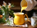 Golden milk made of animal or plant milk, turmeric, cinnamon, ginger and sweetener or honey. Turmeric milk being poored into Royalty Free Stock Photo