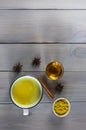 Golden milk, turmeric, honey, ginger root, cinnamon and other ingredients on grey wooden background. Royalty Free Stock Photo