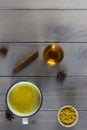 Golden milk, turmeric, honey, ginger root, cinnamon and other ingredients on grey wooden background. Royalty Free Stock Photo