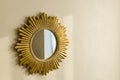 Golden modern mirror in shape of sun on the wall
