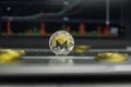 Golden Monero coin with gold coins lying around on a black keyboard of silver laptop and diagram chart graph on a screen