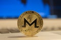 Golden monero stand on silver laptop