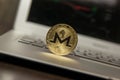 Golden monero stand on silver laptop