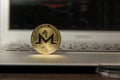 Golden monero stand on silver laptop