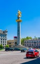 Golden Monument of St. George killing the dragon in Freedom Square in sunny day, centre of Tbilisi, Georgia