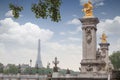 Golden monuments on the bridge Pont Alexander III bridge in Paris overlooking the background the eiffel tower Royalty Free Stock Photo