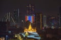 Golden Mount or Wat Saket, Phukhao Thong, and skyscraper buildings with Thailand flag at night in Bangkok City, Thailand. Buddhist