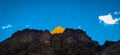 Golden mountain across blue sky at dawn