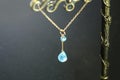 Golden necklace with apatite with green chalcedony with blue topaz on black background.