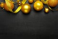 Golden New Year tree toys top view background. Xmas decorations. Winter holidays black wooden backdrop with copyspace. Christmas