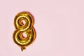 Golden number 8 eight made of inflatable balloon on pink backgro Royalty Free Stock Photo