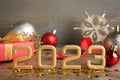 Golden number 2023 and festive decor on wooden table. Happy New Year