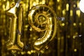 Golden number 19 nineteen from an inflatable balloon, on a yellow background. One of the complete set of numbers. The concept of