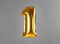 Golden number one balloon on background