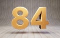 Golden number 84 on wooden floor