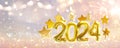 Golden numbers 2024 and stars with sparklers and confetti. Holiday background