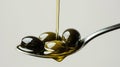 Golden Olive Oil Pouring onto Olives on a Spoon. Royalty Free Stock Photo