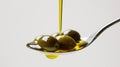 Golden Olive Oil Pouring onto Olives on a Spoon. Royalty Free Stock Photo