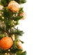 Golden orange bauble ball decorated on green Christmas tree branch with orange lights on white background Royalty Free Stock Photo