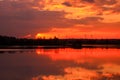 Beautiful dark sunset on the river with symmetry of colorful clouds cumulonimbus. Royalty Free Stock Photo